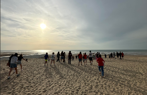 Kinderen rennen op het strand richting zee